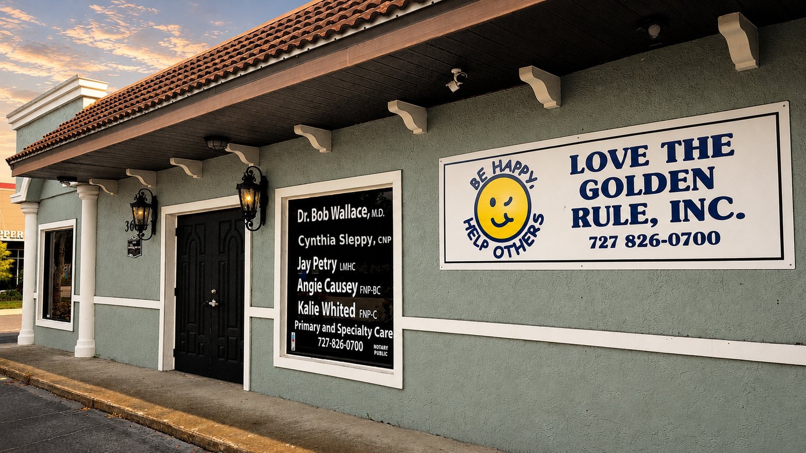 The Love The Golden Rule, Inc. clinic exterior at dusk, with its hand-lettered sign and winking smiley mark